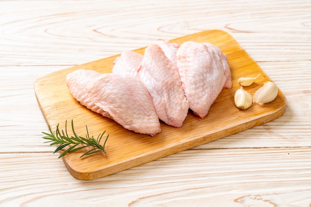 fresh raw middle chicken wings on wooden board