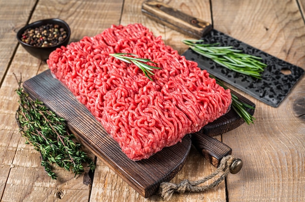 Fresh Raw mince beef  meat on a butcher cutting board with cleaver. Wooden