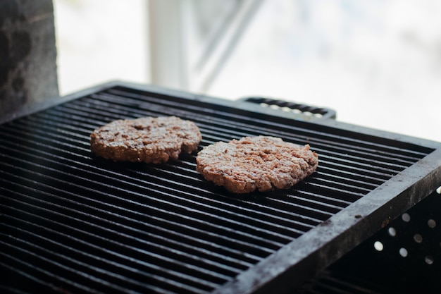 Photo fresh raw minced beef steak burgers with spices on grill.