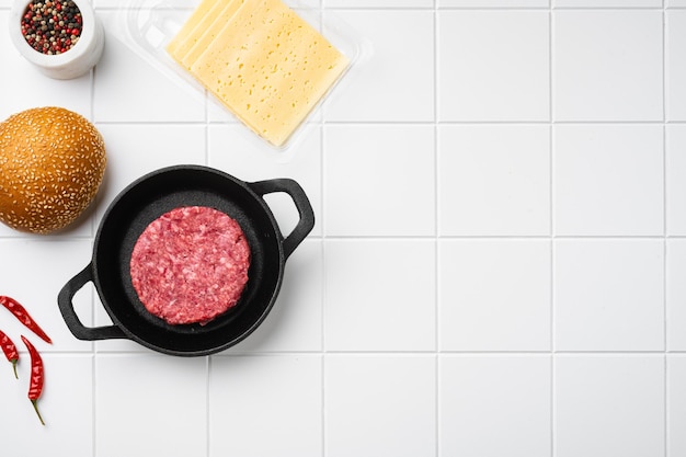 Fresh Raw Minced Homemade Grill Beef Steak Burgers on white ceramic squared tile table background top view flat lay with copy space for text