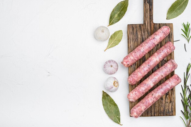 Fresh raw minced meat sausages set on white stone table background top view flat lay with copy space for text