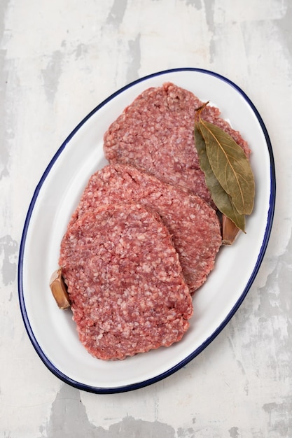 Fresh raw minced meat on white dish on ceramic