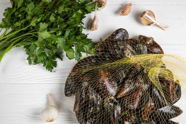 Fresh raw mussels in a grid with parsley and garlic