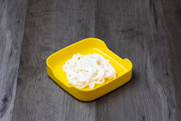 Fresh raw noodle sliced on square plate on wood wooden backgroundset shabu hot pot ingredients