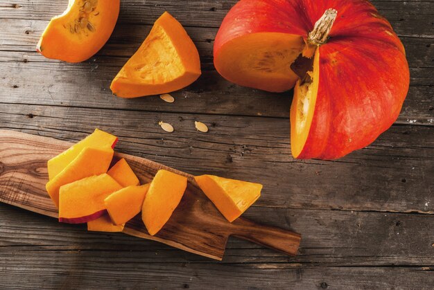 Fresh raw orange organic pumpkin on an old rustic wooden table