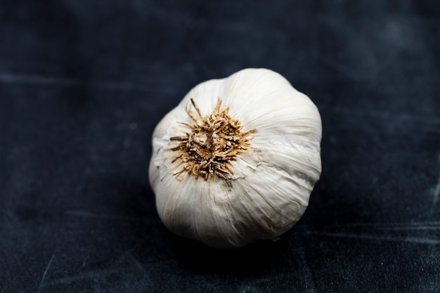 Fresh raw organic garlic on black board.