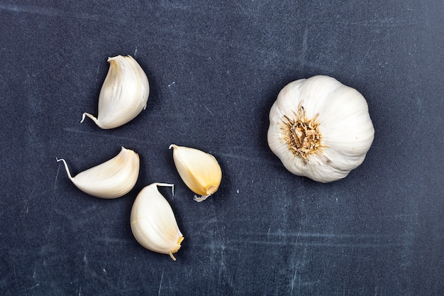 Fresh raw organic garlic on black board.