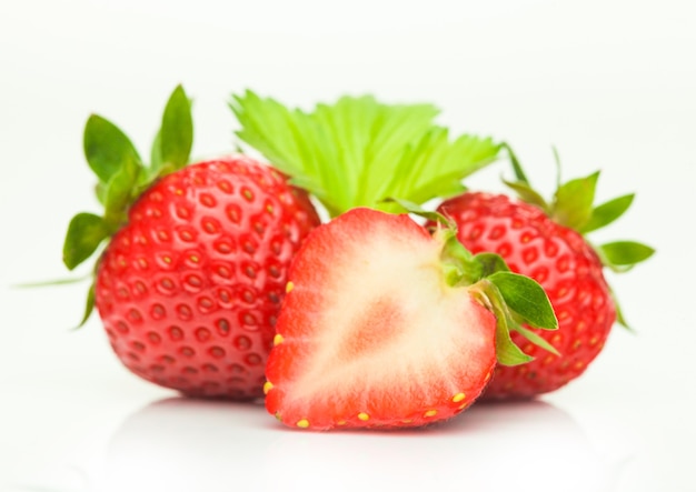 Fresh raw organic strawberries with leaves on white background