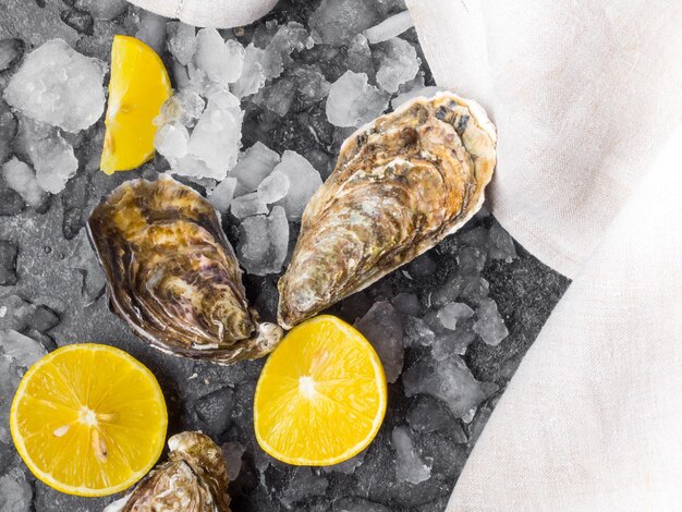 Fresh raw oysters on ice with lemon slices mollusk of the Atlantic Ocean on linen towel