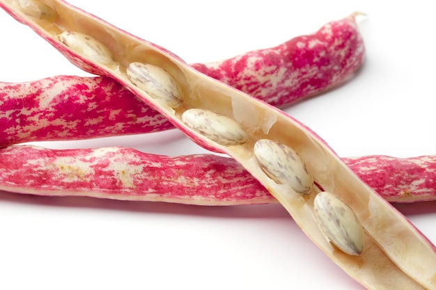 Fresh raw peeled Borlotti beans in the shell on white background