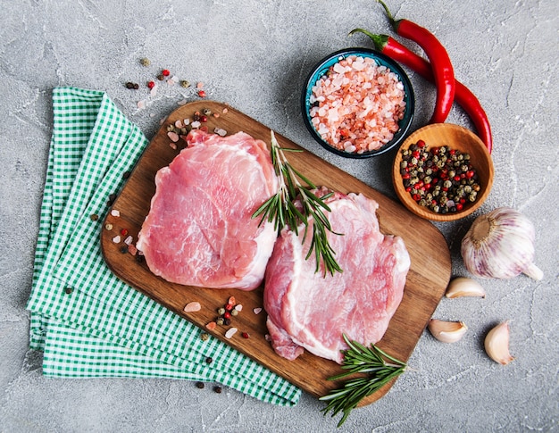 Fresh raw pork chops with spices and herbs