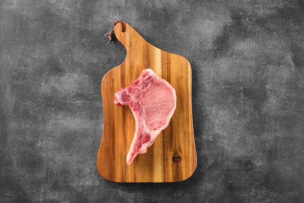 灰色の背景上の骨付き生豚ロース肉の新鮮なポーク チョップ