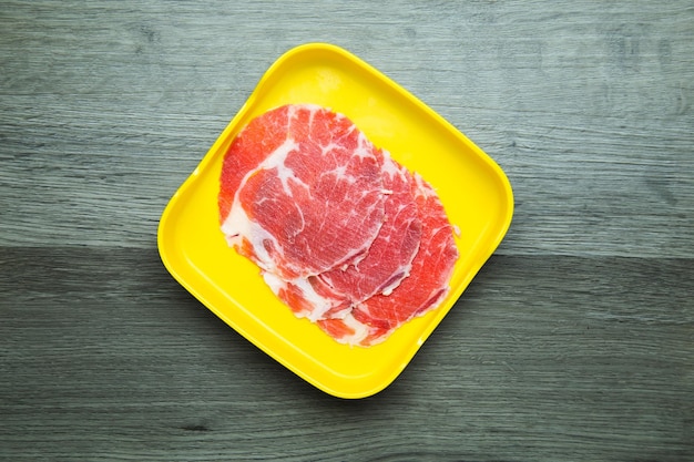 Свежая сырая свинина, говядина, нарезанная на квадратной тарелке на деревянном фоне, набор ингредиентов для горячего горшка сябу