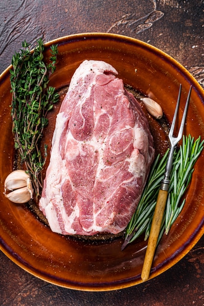 Fresh raw Pork Neck meat steak in rustic plate. Dark