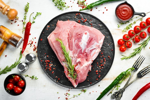 Fresh raw pork shoulder with ingredients and spices on kitchen background Meat Top view Rustic style