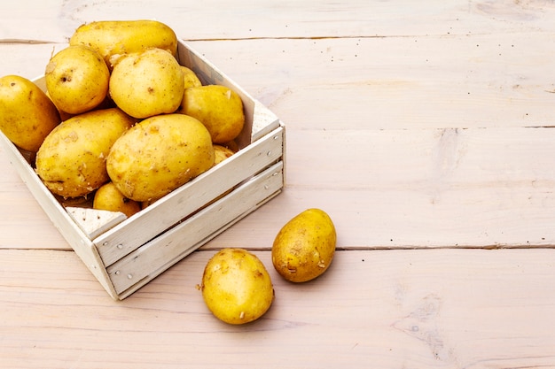 Fresh raw potatoes in wooden box