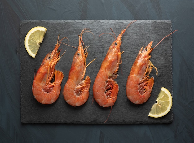 Fresh raw prawns prepared for cooking, on black stone board