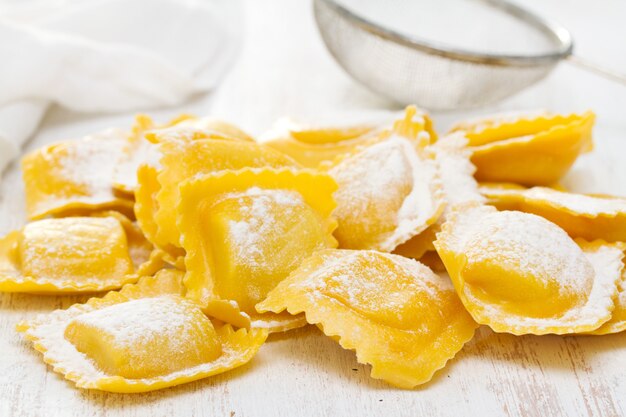 Fresh raw ravioli on wooden surface