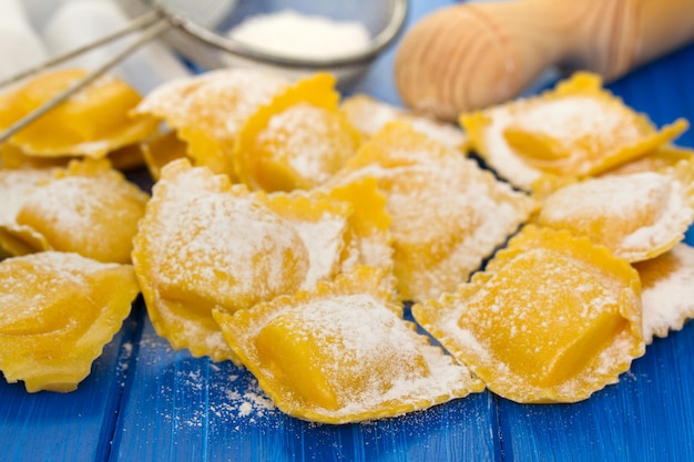 Fresh raw ravioli on wooden surface