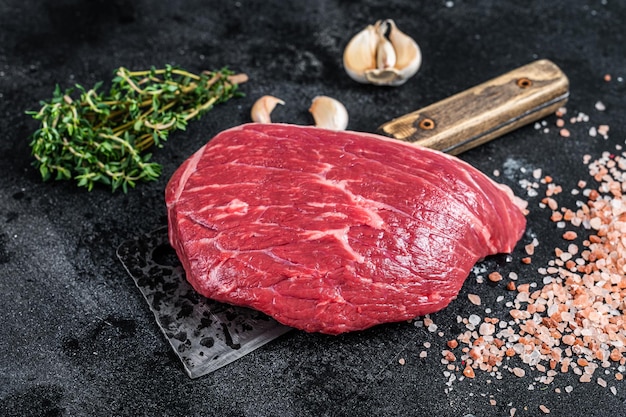 Tagliata di manzo crudo fresco o bistecca di lombata superiore su mannaia da macellaio. sfondo nero. vista dall'alto.