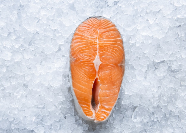 Filetto di salmone crudo fresco su ghiaccio da vicino, pesce freddo dall'oceano, cucina a casa e vista dall'alto del ristorante