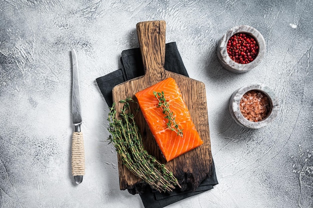 Fresh Raw salmon fillet steak on wooden board. White background. Top view.