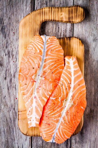 Foto filetto di salmone crudo fresco su una vista dall'alto del tagliere di legno