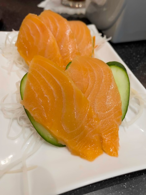 Fresh raw salmon fish sashimi is sliced into pieces in Japanese cuisine