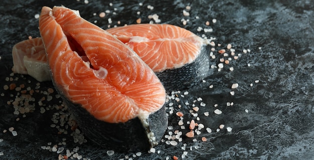 Fresh raw salmon and salt on black smokey