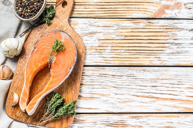 Fresh raw salmon steak with pepper and thyme. 