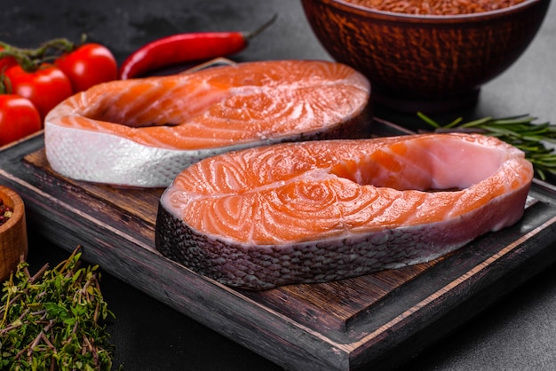 Стейк из свежего сырого лосося со специями и зеленью, приготовленный для запекания на гриле. Здоровая еда из морепродуктов