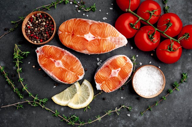 fresh raw salmon steaks with salt, pepper, lemon