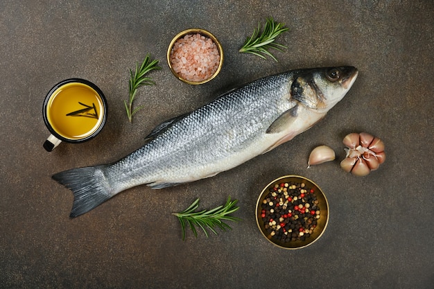 Pesce crudo fresco del branzino sulla tavola con le spezie