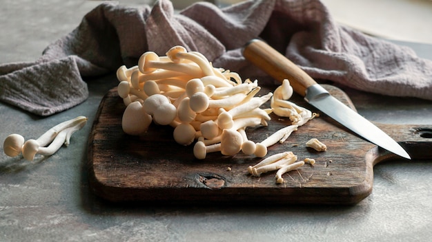 Photo fresh raw shimeji mushrooms on thr old wooden cutting board