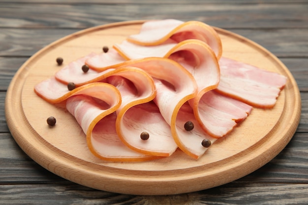 Photo fresh raw sliced bacon on the wooden cutting board
