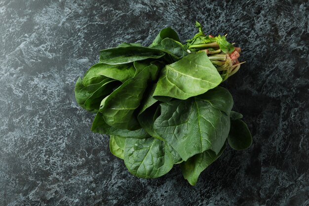 Fresh raw spinach on black smokey