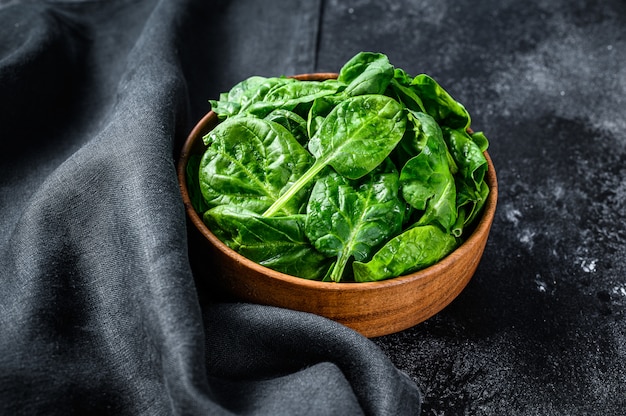 Fresh raw spinach in a wooden bowl