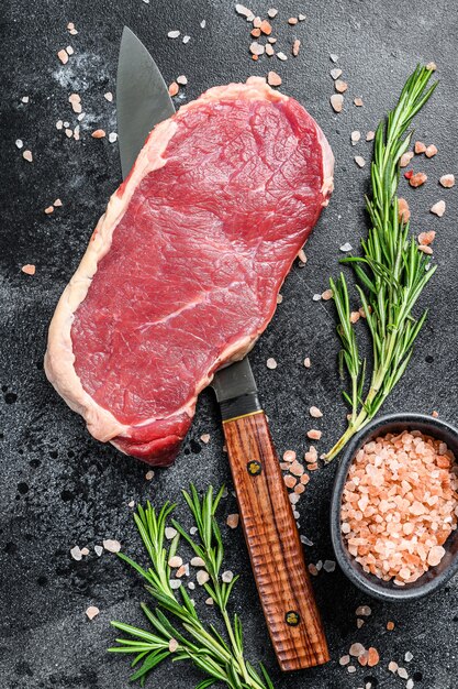 Fresh raw steak with spices on the table