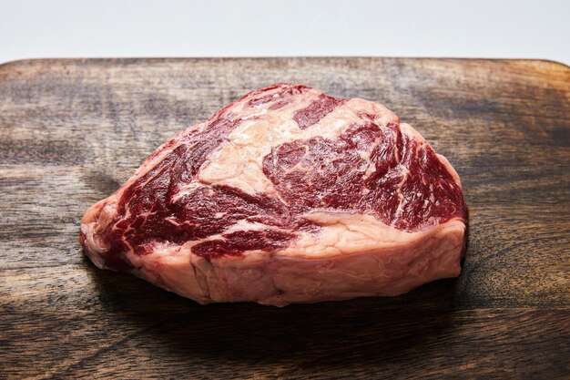 Fresh raw steak on wooden cutting board