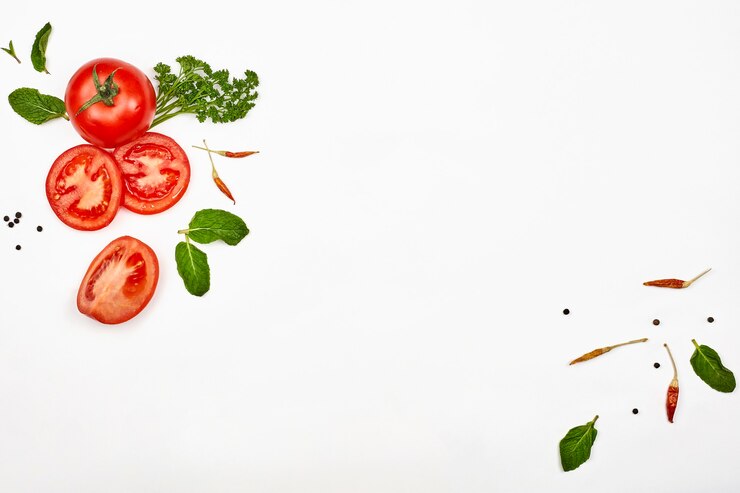 Fresh raw tomatoes and green herbs on white background with copy space. Organic vegetables on white