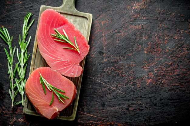 Foto bistecca di tonno crudo fresco su un tagliere con rosmarino