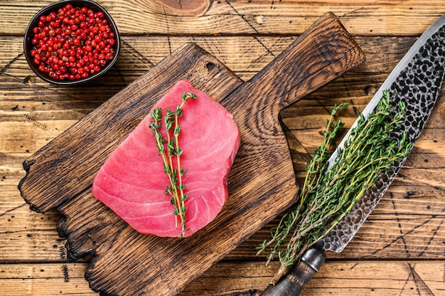 Fresh Raw tuna steak on a wooden cutting Board with knife.