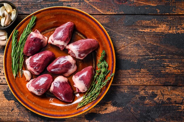 Fresh Raw turkey hearts offal giblets with  thyme and rosemary