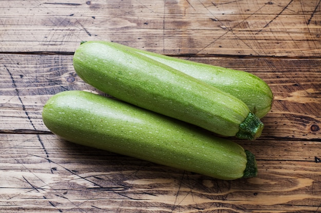 Fresh raw zucchini ready to eat on wooden background with copy space.