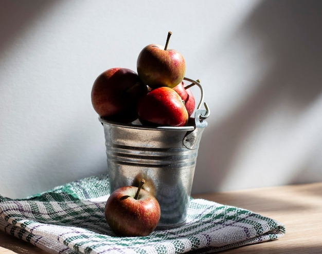 Fresh red apples in a bucket under the sun