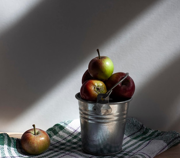 Fresh red apples in a bucket under the sun