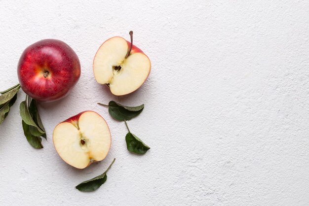 Photo fresh red apples with green leaves on wooden table on wooden background top view free space for text