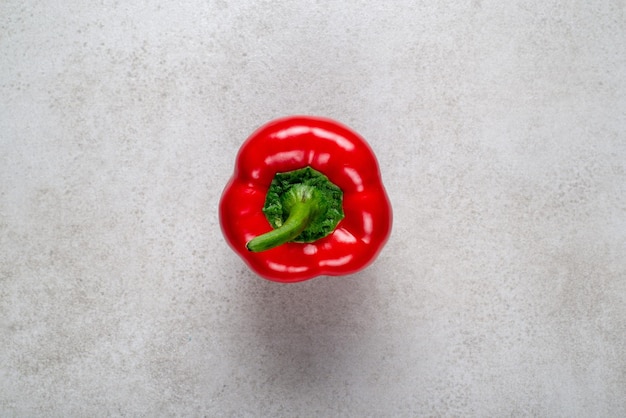 Fresh red bell pepper with drops of water on a gray stone Background illustration for advertising re