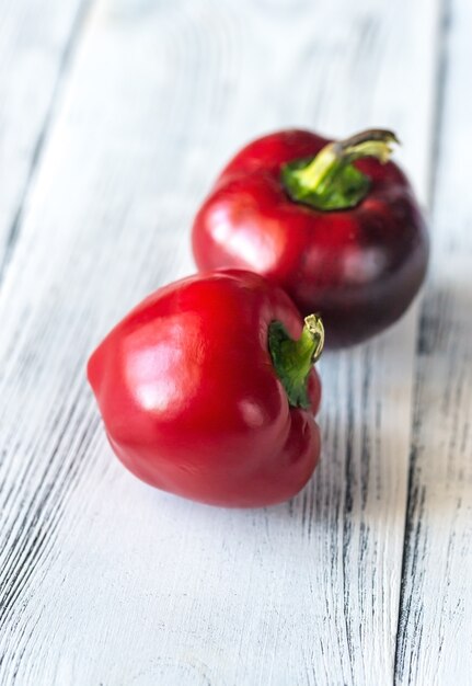 Peperoni dolci rossi freschi sulla tavola di legno