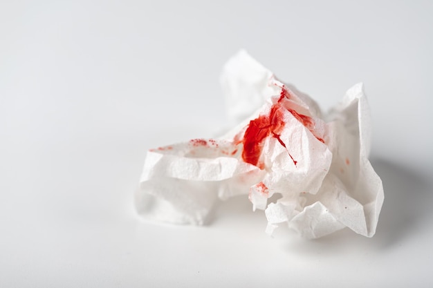 Photo fresh red blood stained on tissue paper on white table